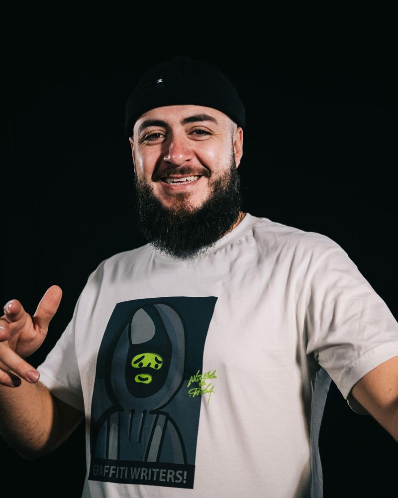 Deivid sorrindo, de gorro, apontando para a câmera